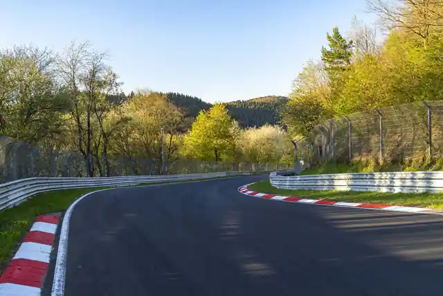 Freie Streckenkurve am Nürburgring als mögliche Kulisse für Fahrzeugaufnahmen.